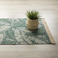 Dywan z frędzlami Jungle 120x170 cm Wykonany z przyjemnego w dotyku materiału, ozdobiony tropikalnym motywem, prostokątny kształt i kremowo zielona kolorystyka